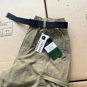 Detailed macro shot of khaki men's quick-dry cargo pants with functional pockets and belt