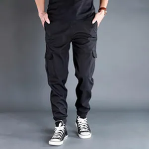 Close-up detail of mens black cargo jogger pants with side flap pockets and elastic cuffs