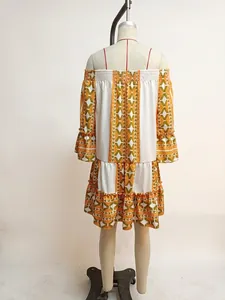 Detail of an off-shoulder summer dress with flared sleeves and orange geometric pattern.