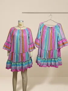 Colorful striped boho vacation dress with ruffled flare sleeves in a warehouse setting