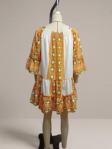 Back view of a white and orange geometric pattern patchwork flare sleeve resort dress