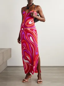 Detailansicht eines lebhaften psychedelischen Drucks auf einem Satin-Trägerkleid mit Schlitz