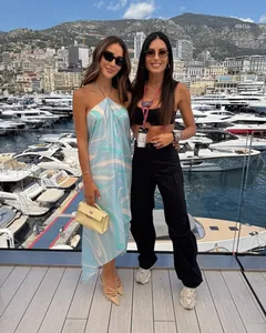 Fashionable woman in a blue swirl print satin halter dress at a luxury harbor