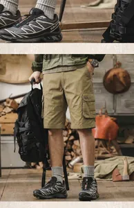 Close-up detail of men's khaki cotton cargo shorts featured in a rustic outdoor camping setting