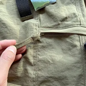 Detailed close-up of zipper and breathable fabric on men's quick-dry cargo pants