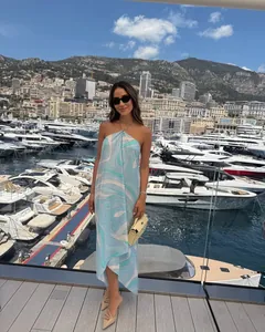Elegant blue marble print satin halter dress with asymmetric hem in a yacht marina