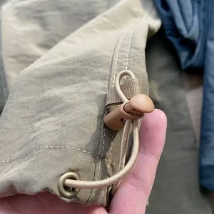 Macro view of adjustable drawstring hem on quick-dry breathable cargo trousers.