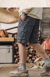 Detailed side view of men's dark grey cotton cargo shorts with functional pockets