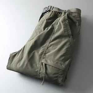 Detail view of olive green quick-dry cargo pants with built-in belt and side pockets