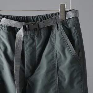 Detail shot of men's quick-dry cargo pants with adjustable nylon belt and buckle.