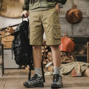 Men's summer cotton khaki cargo shorts with side pockets in a rustic workshop outdoor style