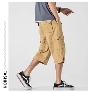 Side view of men's loose khaki cargo capri pants with multiple utility pockets.