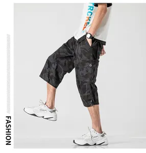 Detail view of men's loose camouflage cargo shorts with functional side pockets.