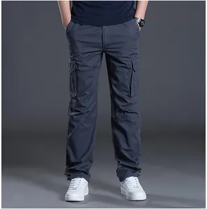 Front view of men's dark grey multi-pocket cargo pants paired with white sneakers.