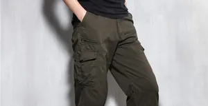 Detailed view of men's olive cargo pants with multiple functional side pockets and zip detail