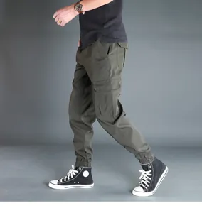 Vista laterale dei pantaloni cargo verde oliva da uomo con polsini elastici e tasche