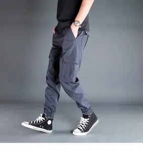 Vista laterale di pantaloni cargo da uomo grigio scuro con tasche laterali a pattina