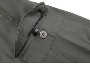 Primo piano di una tasca per pantaloni cargo verde oliva con bottone e patta rinforzata