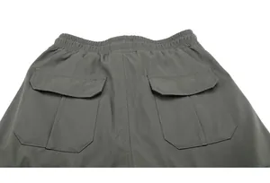 Dettaglio dei pantaloni cargo grigi con due grandi tasche con patta e vita elasticizzata