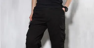 Detail view of men's lightweight black cargo pants featuring multi-pocket design