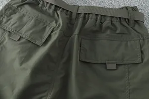 Détail des poches arrière à rabat et de la taille élastique d'un pantalon de randonnée vert.