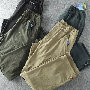 Water-repellent texture of men's lightweight outdoor cargo pants in various earthy colors.