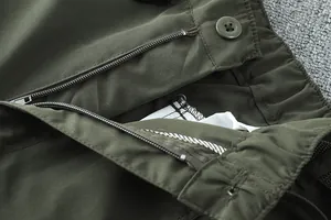 Vue détaillée de la fermeture éclair et du bouton du pantalon extérieur vert olive