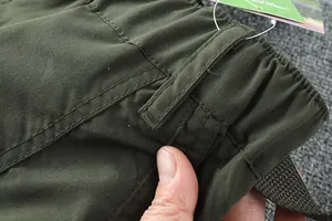 Détail rapproché de la couture de la taille et du tissu du pantalon de randonnée vert