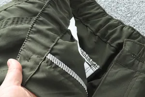 Détail de la taille élastique et des coutures renforcées sur un pantalon d'extérieur vert