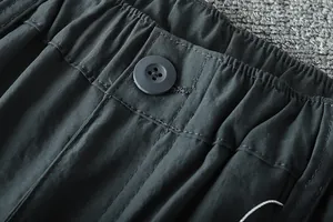 Detail of the elastic waistband and button on men's outdoor lightweight cargo pants.