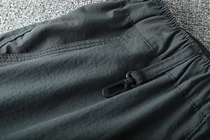 Detailed view of elastic waistband and functional pocket clip on outdoor cargo pants