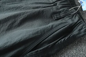 Close-up of elastic waist and pocket detail on men's lightweight outdoor cargo pants.