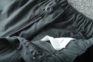 Close-up of elastic waist and zipper on men's lightweight outdoor cargo pants.