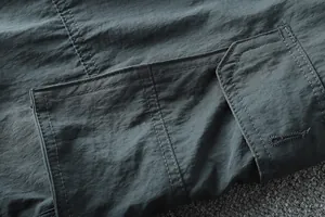 Close-up detail showing the durable fabric texture and cargo pocket of men's outdoor pants