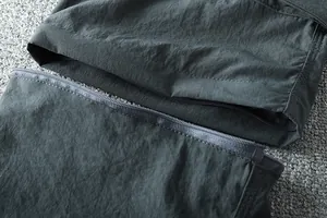 Macro detail of the detachable leg zipper on men's outdoor convertible cargo pants