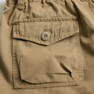 High quality close-up of khaki cargo shorts featuring a durable flap pocket with button closure