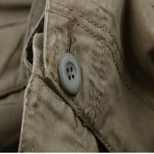 Close-up macro detail of a button and durable stitching on khaki cargo pants material