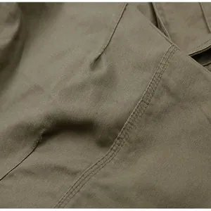 Close-up detail of olive green cargo pants fabric showing durable texture and double stitching