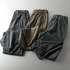 Close-up detail of outdoor waterproof tactical pants in gray, olive and brown colors