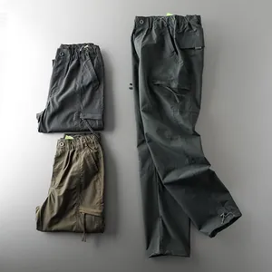 Detail view of men's waterproof tactical cargo pants in dark grey and army green
