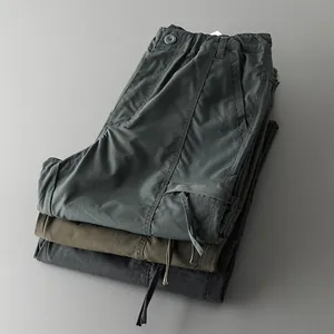 Close-up of stacked outdoor cargo pants showing fabric texture and color variety for men