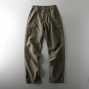 Olive green men's tactical cargo pants with waterproof finish and drawstring cuffs