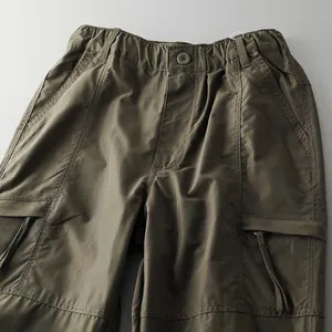 Close-up detail of men's olive green waterproof outdoor tactical cargo pants