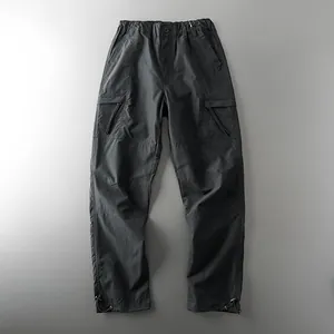Detailed view of men's waterproof outdoor tactical cargo pants in dark grey fabric