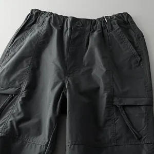 Close-up of black tactical outdoor cargo pants with elastic waist and zipper pockets