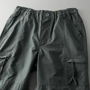 Detail view of the waistband and pockets of durable dark gray men's cargo pants