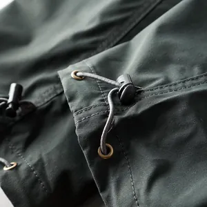 Detail view of the drawstring toggle and eyelets on men's outdoor waterproof cargo pants