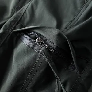 Macro view of the waterproof sealed zipper detail on dark olive tactical outdoor pants