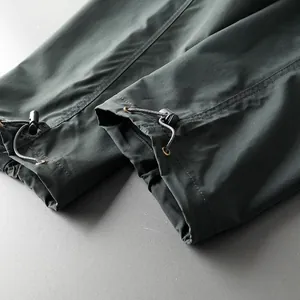 Detail of waterproof hiking pants with adjustable drawstring cuffs and toggles.