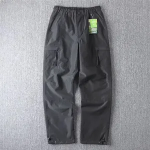 Detailed view of black multi-pocket cargo pants with adjustable drawstrings.